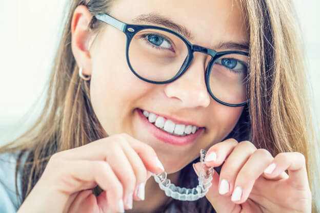 teenage girl holding invisalign