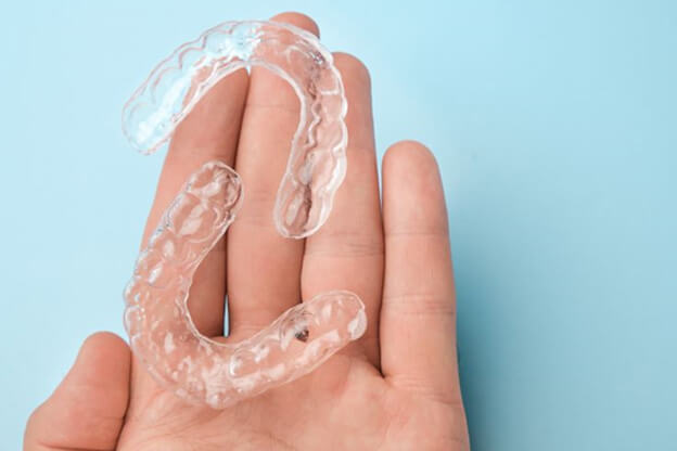 two clear aligners resting on persons hand