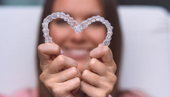 patient making heart with aligners